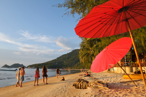Koh Tao, Thailand - October 14, 2011: People walk down Sairee Beach on the west side of Ko Tao, an island particularly popular with scuba divers and backpackers.