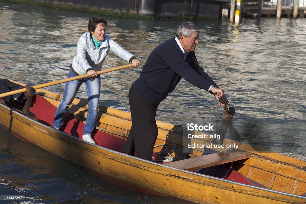 Couple de rameurs debout dans leur bateau. - Photo de Adulte libre de droits