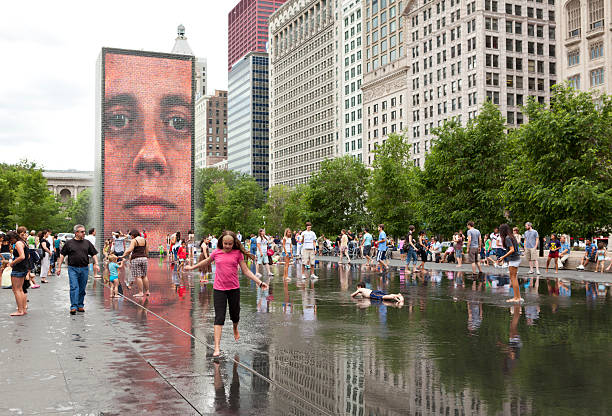 Crown Fountain in Downtown Chicago "Chicago, USA- June 29, 2011: Children playing in water of the Crown Fountain located in Millennium Park in downtown Chicago" millennium park chicago stock pictures, royalty-free photos & images