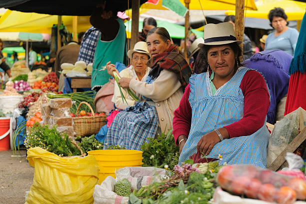 Ecuador, Ethnic latin woman Gualaceo, Ecuador - August 22, 2012: Ecuadorian ethnic women in national clothes selling agricultural products and other food items on a market in the Gualaceo village quito photos stock pictures, royalty-free photos & images