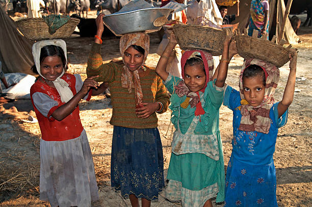 Child Labor "Sonepur, Bihar, India - November 28, 2007: Group of Indian children collecting animal manure for use as fuel at the Sonepur Mela or fair. The Sonepur Mela is an annual event held near the confluence of the Ganges and Gandak Rivers and is timed to begin on the full moon of the Hindu month of Kartik Purnima. Sonepur is normally a small rural hamlet, but comes alive every year with the arrival of tens of thousands of visitors and accompanying livestock." child labor stock pictures, royalty-free photos & images
