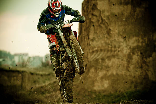 Motocross rider jumping on extreme terrain at sunset. Copy space.
