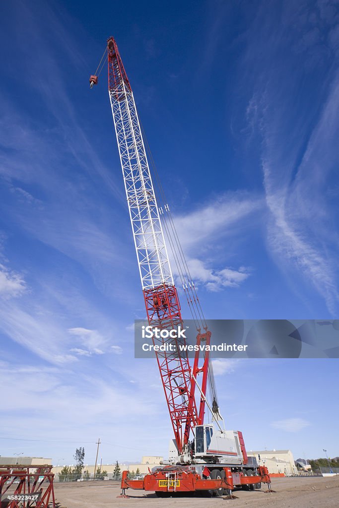 Heavy Equipment Mobile Crane A large construction crane mounted on a vehicle.  The tall crane arm reaches high into the sky. Blue Stock Photo