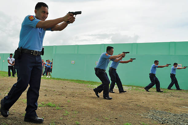 Silang, Cavite, Philippines -September 26, 2009: Personnel of Philippine National Police on their shooting practice in walking firing assault as one of their practical exercise on their Officer Advance Course schooling at the firing range of National Police College, Satellite Campus at General Mariano N Castaneda, Silang, Cavite as part of the 10-Point Action Plan of Chief PNP Police Director General Nicanor A Bartolome, Enhancement and Specialization of Skills ; training and seminars on investigation, resource management, disaster response and other related courses help develop the competencies, specialization and enhancement of individual skills of every police personnel.