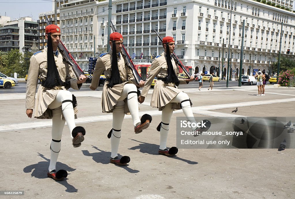 Athens parliament honor guard Athens, Greece - July 06, 2012: Constitution Square (Syntagma Square) before Greek parliament at noon, changing of the honor guard. Three soldiers marching in traditional military uniform in skirts and shoes with big black pompoms. Adult Stock Photo