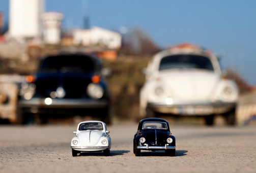 Istanbul, Turkey, 19th Feb, 2012: Black and White Volkswagen Beetle Toys are standing in front of original black and white Volkswagen Beetles
