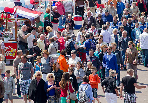 Scheveningen, Holland - June 8, 2013: Crowd of people walk among the stalls at the annual outdoor Vlaggetjesdag festival in the fishing town of Scheveningen, Holland on June 8, 2013