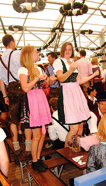 oktoberfest_young femmes dansant sur le banc - lederhosen oktoberfest beer dancing photos et images de collection