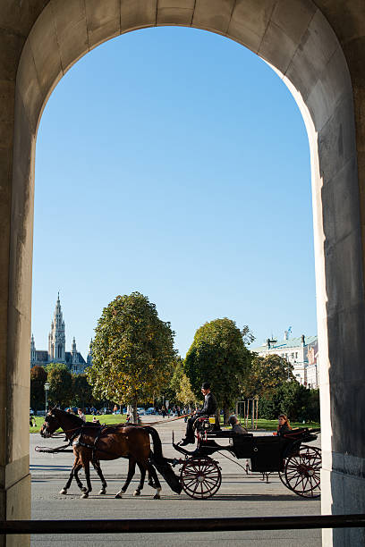 Vienna, Austria - October 3, 2012: Traditional horses and carriage (also called Fiaker) passing the famous Hofburg on October 3, 2012 in Vienna, Austria. The Fiaker rides are a traditional tourist attraction -200 carriages are available each day in this city.