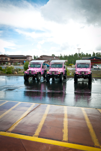 Tusayan, Arizona, USA - September 12th, 2012: Three pink Jeeps parked in front of National Geographic Grand Canyon Visitor Centre(not seen),  