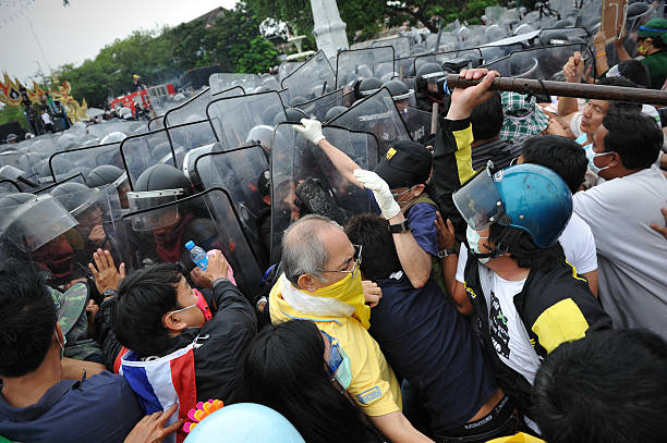 Anti-Government Rally in Bangkok Bangkok, Thailand - November 24, 2012: Anti-government protesters from the nationalist Pitak Siam group clash with riot police at a barricade on Makhawan Bridge. Pitak Siam are calling for the government to be overthrown. peoples alliance for democracy stock pictures, royalty-free photos & images