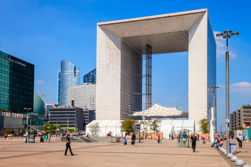 Paris, France - May 21, 2010: Tourists walking in the central square of La Defense, in the background is The Big Arch monument.