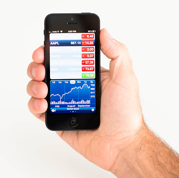 neue apple iphone 5 mit stock market app - holding iphone 5 business mobile phone stock-fotos und bilder