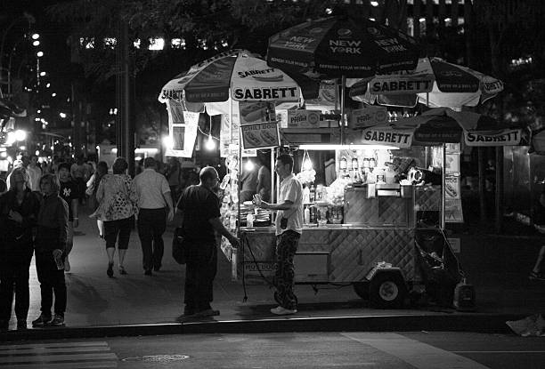 New York City, NY, USA - August 23, 2012: Hot dog vendor making a sale among the pedestrians in Mid-town Manhattan, NY in the summer of 2012.