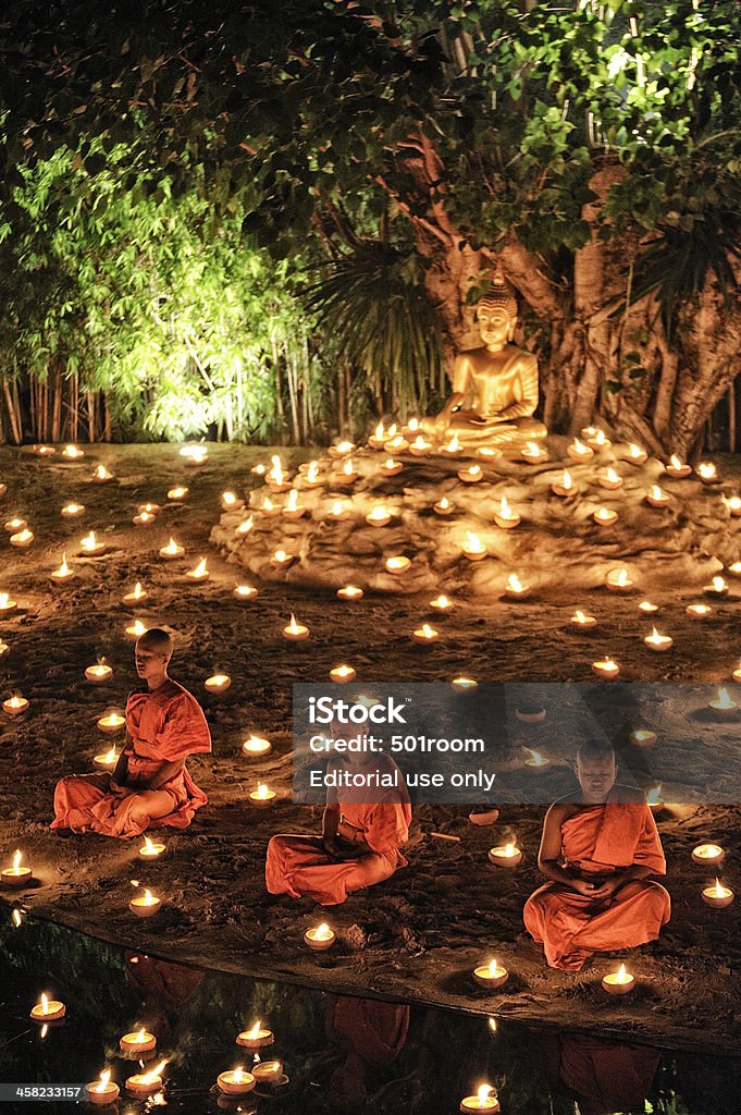 Monks sitting meditation Chiang Mai, Thailand - November 28, 2012: Group of monks sitting meditation in the sacred ritual annually at Wat Phan Tao temple during the Loi Krathong Festival. Adulation Stock Photo