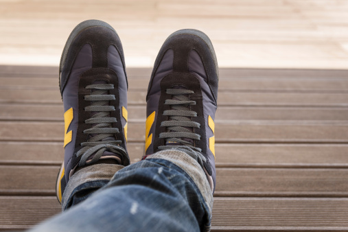 Rimini, Italy - May 26, 2013: Close up of the wearing the new balance shoes sniker model M360 on wood background. New Balance is an american footwear manufacturer based in the Brighton, new Boston.