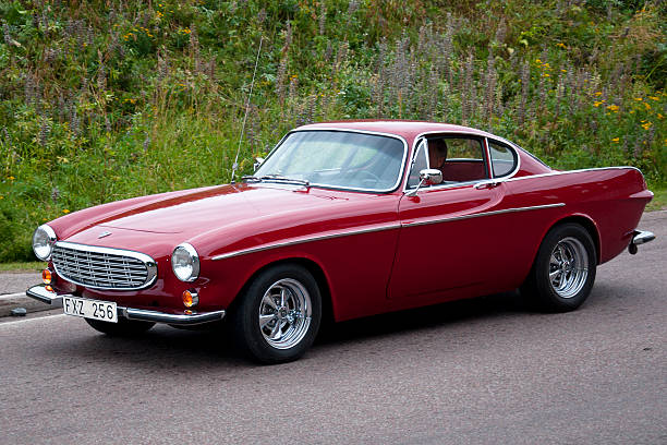 Volvo P1800 from 1967 Sater, Sweden - July 23, 2010: An old car Volvo P1800 from 1975, in a classic car cavalcade on small public roads around the small town Sater in Sweden volvo 1800 es stock pictures, royalty-free photos & images