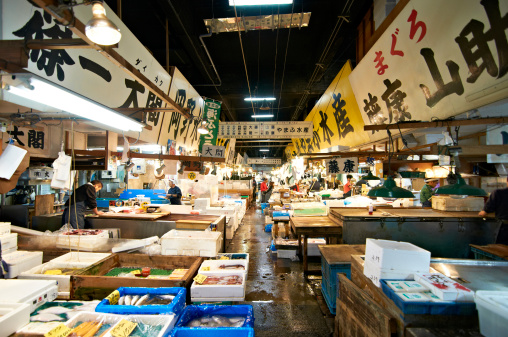 Tokyo, Japan - October 20th 2011: Tsukiji Market. Retailers selling and cutting fish at Tsukiji fish market in the morning, Japan's largest fish market. We can see many different kinds of fishes in the boxes.