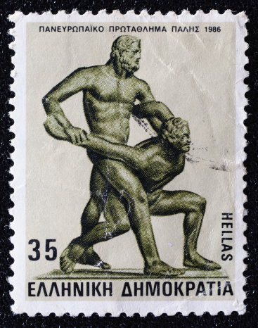 Bandung, West Java, Indonesia, July 16, 2012: A postage stamp printed in Greece shows traditional Greece sport, wrestling.