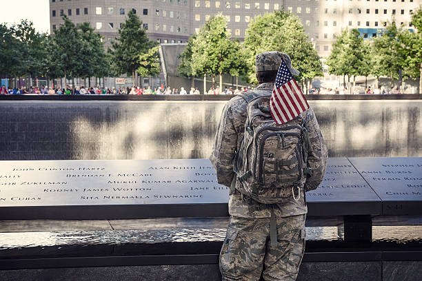 Eternal Memory to 9/11 victums New York City, USA - Sep 2012:  Soldier is staying near Memorial at World Trade Center Ground Zero. Image was taken near south tower pool memorial event photos stock pictures, royalty-free photos & images