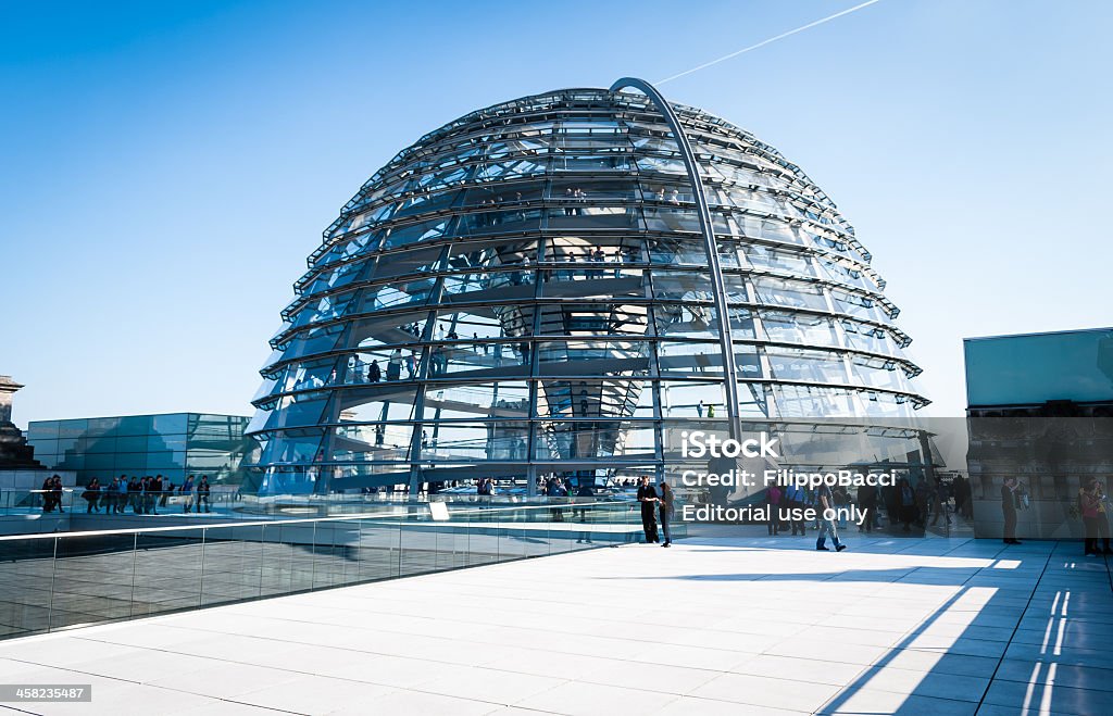 Reichstag glass dome Berlin, Germany - March 23, 2012: Reichstag glass dome construction above German parliament (Bundestag). Construction of cupola (designed by architect Norman Foster) was finished in 1999, the seat of Bundestag was transfered here also same year. People visiting the monument on the rooftop. Bundestag Stock Photo