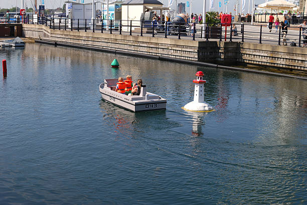 Portsmouth, England - September 4, 2012: Children with mother riding on model boat at Gunwharf Quays.