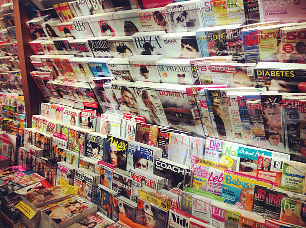 Newsstand with German Magazines Cologne,Germany- September 26,2012: Popular german magazines in german language displayed inside a newsstnd on the central station(Cologne,Germany) vogue cover stock pictures, royalty-free photos & images