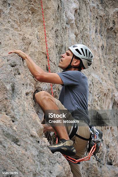 Uomo Climber Stringere Per Una Scogliera - Fotografie stock e altre immagini di Ambientazione esterna - Ambientazione esterna, Arrampicata su roccia, Attività ricreativa