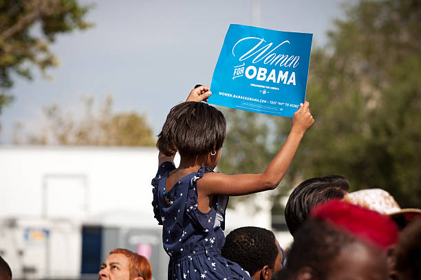 Las Vegas, Nevada - November 1st, 2012: a young African American Girl holds up a sign at a political rally for President Barack Obama atop her Father's shoulders. This was the President's last rally in Nevada before his re-election bid in 2012.
