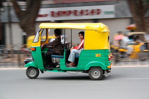 Bangalore, India - August 8, 2010: Boy taking an Auto rickshaw ride in Bangalore city.