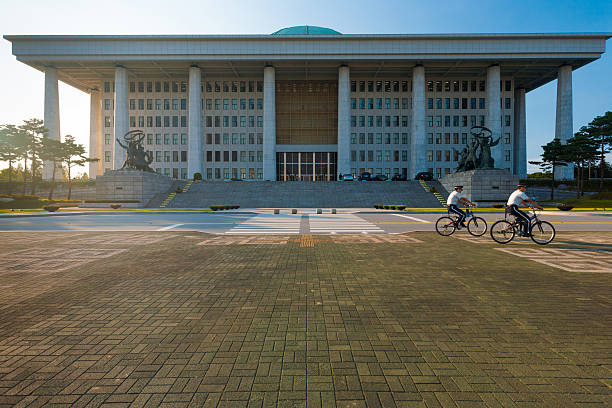 Seoul, Korea - September 8, 2009: Unidentified policemen bicycle in front of the National Assembly building, home to the legislative branch of government, in Seoul, South Korea on September 8, 2009