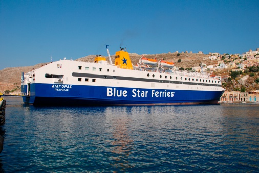 Symi, Greece - June 21, 2011: Blue Star Ferries ship Diagoras docked in Yialos harbour on the Greek island of Symi. Built in 1990 the ship is 141 metres long.
