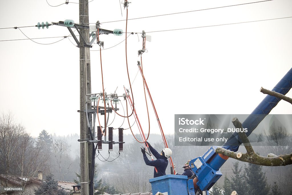 Hommes fonctionnent sur un bâton électrique - Photo de Électricité libre de droits