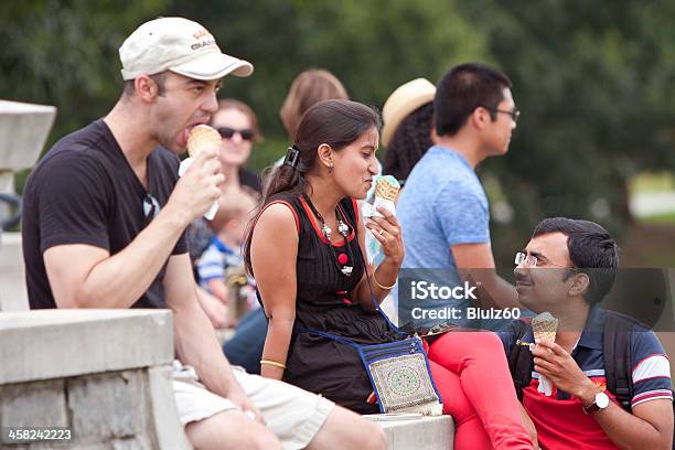 Young Adults Enjoy Eating Ice Cream Cones At Summer Festival Stock Photo - Download Image Now