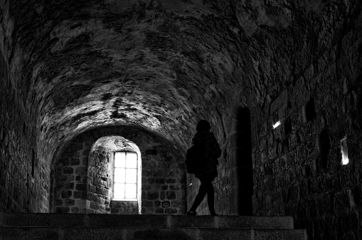 Paris, France - June 11, 2012 . One woman walking in the medieval church of Mont Saint-Michel, the famous UNESCO World Heritage Site in France, Europe.