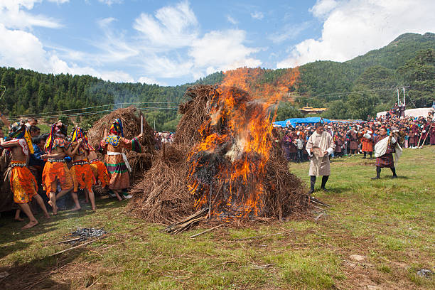Mönche springen über zwei Brennen haystacks im Thangbi festival – Foto