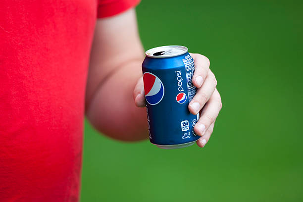 Man Drinking Pepsi Cola Merrimac, Wisconsin, USA - June 29, 2013: A man holds an open can of Pepsi while celebrating at an outdoor barbecue on a beautiful summer day. quench your thirst pictures stock pictures, royalty-free photos & images