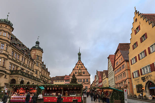 Rothenburg ob der Tauber, Germany - December 18, 2012: People visiting the tiny Marktplatz, which hosts the lovely Christmas market. For its medieval well-preserved buildings and the romantic atmosphere of the old town, Rothenburg ob der Tauber is also known as the Christmas village.