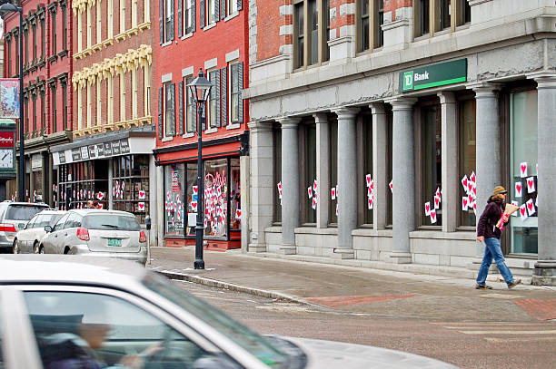 Montpelier, Vermont, USA - February 14, 2010: On Valentine's Day, a man carries flowers as he comes to the intersection of State and Main Streets in Montpelier.  Hearts have been hung in all the shop windows by the mysterious Valentine Phantom who decorates the downtown every year on Valentine's Day.