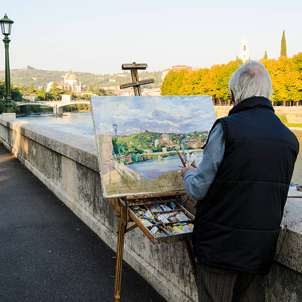 rua pintor segurando paintbrushes e pintura verona - oil painting fine art painting watercolor painting river - fotografias e filmes do acervo