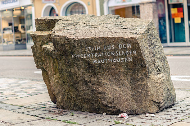 Braunau, Austria - September 30, 2012: Memorial at the birthplace of Adolf Hitler  in Braunau am Inn (Austria). A rock from the Mauthausen concentration camp, with the inscription \