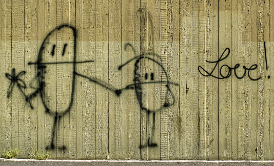 Wuerzburg, Germany May 19, 2013: Graffiti of two pills in love. on a green wall near the railway station in Wuerzburg.