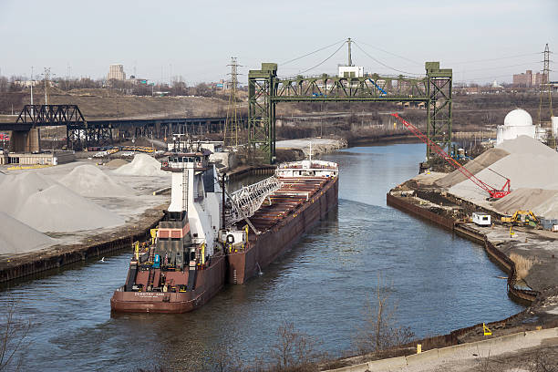Upbound On The Cuyahoga Cleveland, USA - March 9, 2013: Among the first to start the 2013 Great Lakes shipping season are the tugboat Dorothy Ann and the barge Pathfinder upbound on the Cuyahoga River with a load of Taconite for a local steel mill on March 9, 2013 at Cleveland, Ohio river cuyahoga stock pictures, royalty-free photos & images