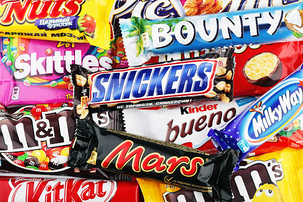 Closeup of a variety chocolate bars Tula, Russia - December 10, 2012: This is a studio shot of a variety chocolate bars including Snickers, Bounty, Mars, Kinder Bueno, Kit Kat, Nuts, Skittles, Milky Way, Picnic, M+M's. brand name photos stock pictures, royalty-free photos & images