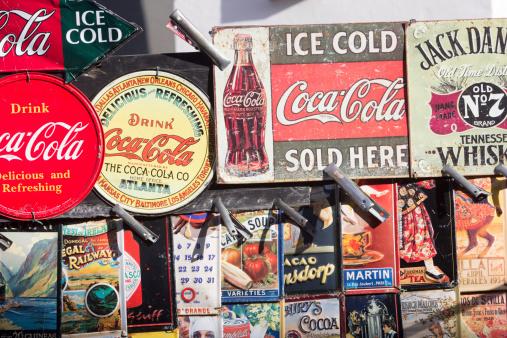 London, England - February 2, 2013: Portobello Market has many antiques for sale, including these old fashioned but collectible advertising labels. Pictured at the top here are Coca-Cola and Jack Daniels Tennessee Whisky