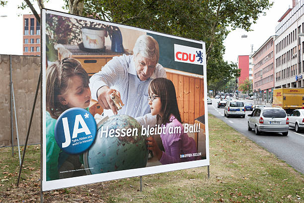 Election campaign billboard of CDU / Landtagswahlkampf 2013 Wiesbaden, Germany - August 9, 2013: Election campaign billboards of the German Christian Democrats (CDU) in the city center of Wiesbaden, Hessen. German federal state Hessen faces state elections scheduled for September 22. Some passersby and road users in the background. german federal elections photos stock pictures, royalty-free photos & images