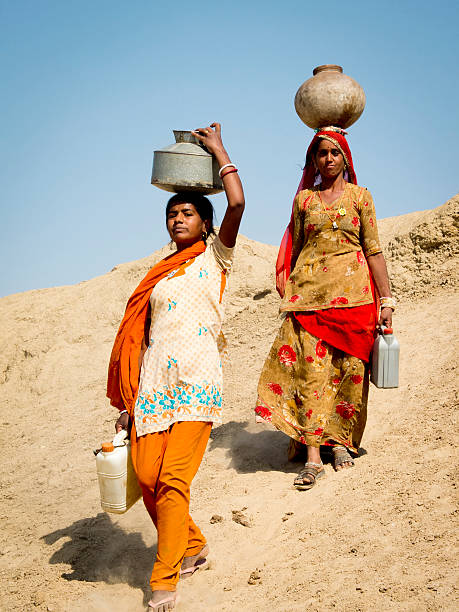 Jaisalmer, India - March 8, 2013: Close-up portrait of two women carrying water in the desert.