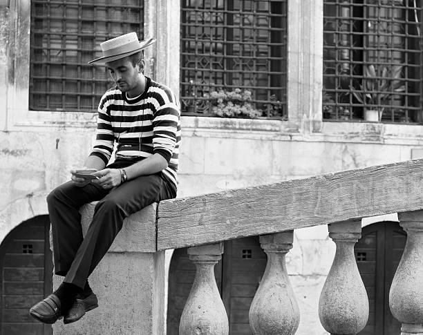 gondoliere con telefonino 、venezia -ベニス、スマートフォン、ゴンドラの船頭 - men gondolier people activity ストックフォトと画像