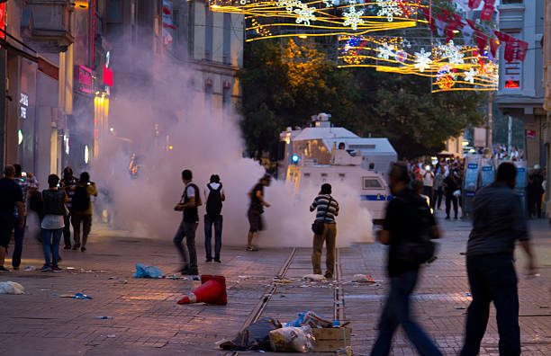 Protests in Turkey Istanbul, Turkey - July 31, 2013: Police intervene protestors with tear gas in Istiklal Street. People gathered and protest for police who used disproportionate force to protesters and wounded Berkin Elvan. riot tear gas stock pictures, royalty-free photos & images