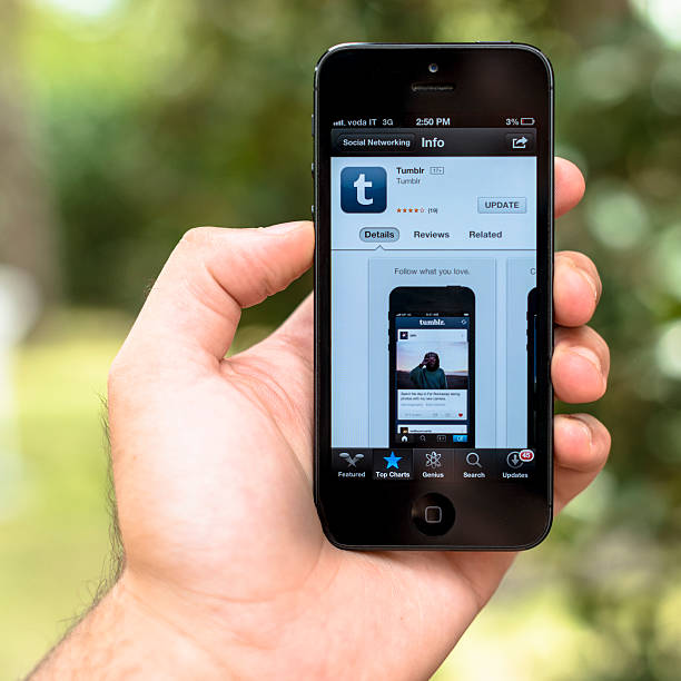 Pisa, Italy - August 7, 2013: Human hand holding the new Apple Iphone 5 with tumblr app on the apple store. Tumblr is a social media platform for create website with a cms.  The iphone 5 is the new smartphone made by Apple Inc. It was released on September 21st on US and Uk 2012, the iPhone 5 is Apple's first mobile phone with a 4\